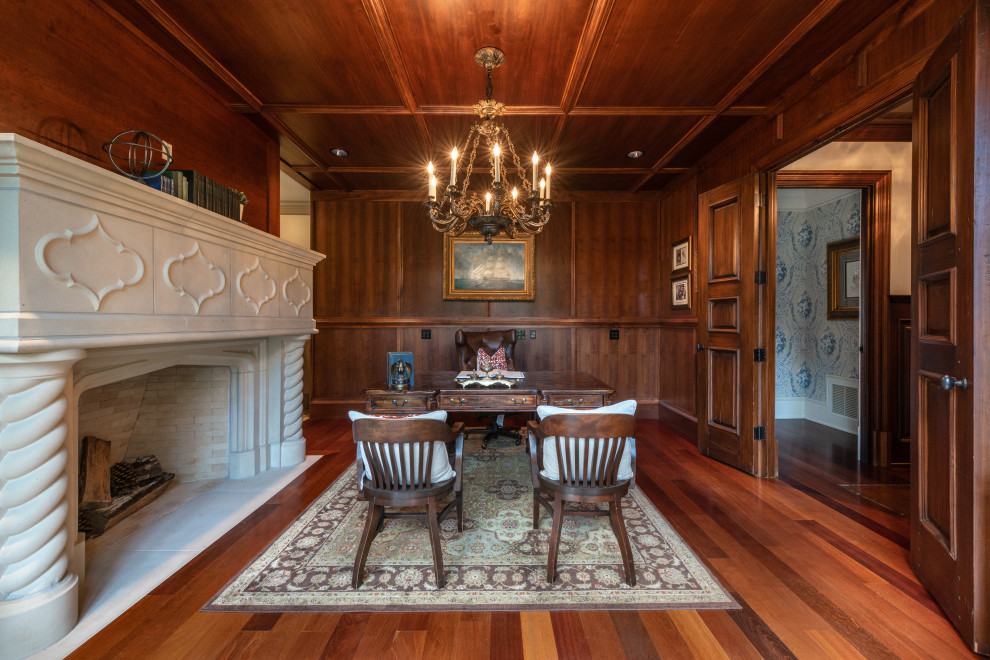 Photo of a large study in Atlanta with brown walls, dark hardwood flooring, a standard fireplace, a concrete fireplace surround, a freestanding desk, brown floors, a wood ceiling and panelled walls.