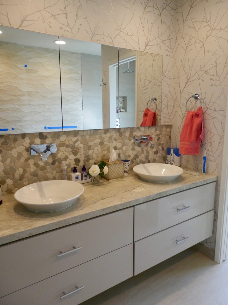 Inspiration for a mid-sized transitional master porcelain tile and beige floor alcove shower remodel with flat-panel cabinets, beige cabinets, beige walls, a vessel sink, quartzite countertops, a hinged shower door and beige countertops
