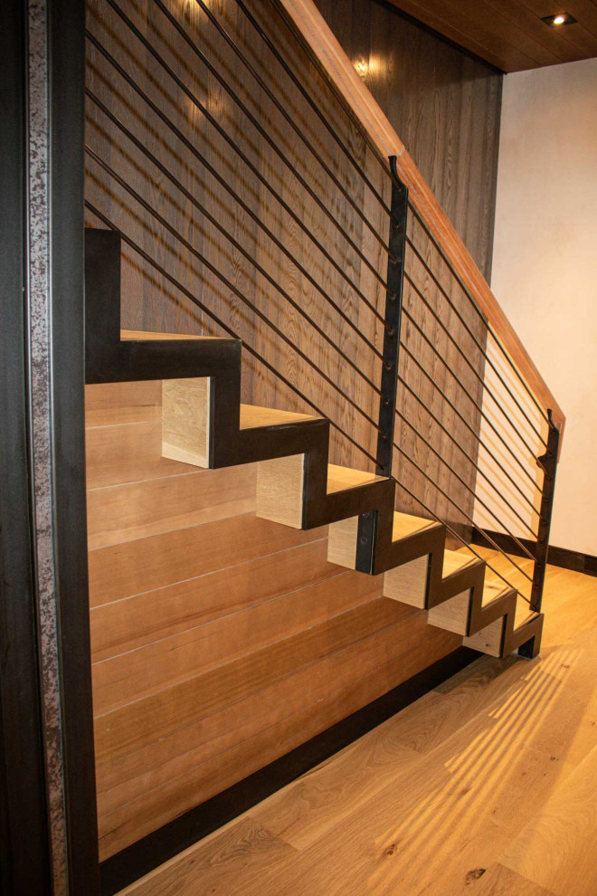 Wood straight staircase in Other with wood risers, metal railing and panelled walls.