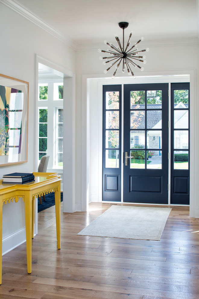 Mid-sized traditional foyer in Minneapolis with white walls, light hardwood floors, a single front door and a glass front door.