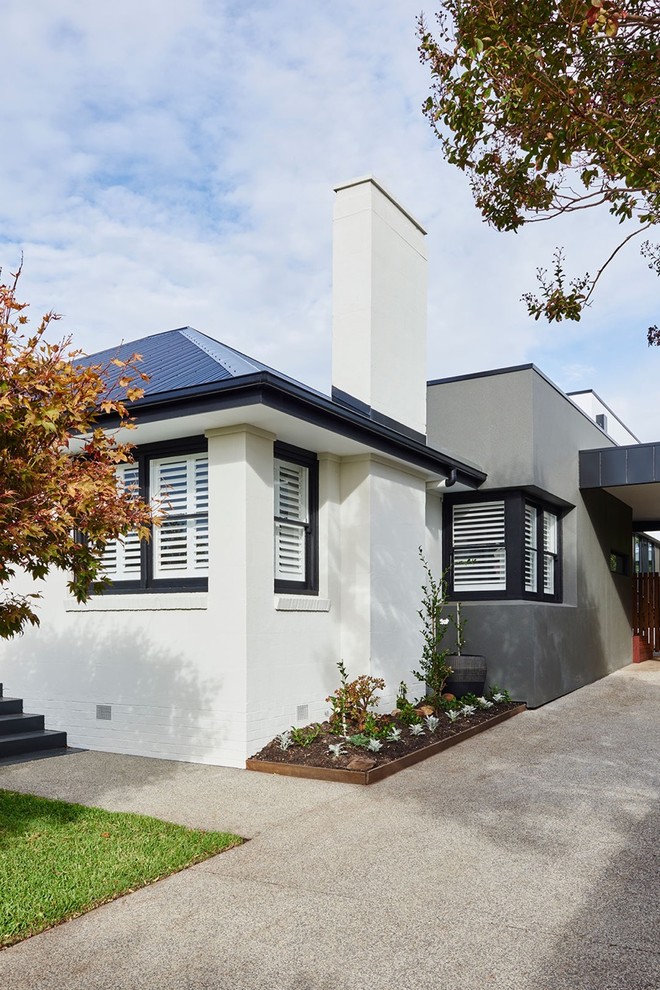 Inspiration for a mid-sized modern one-storey white house exterior in Geelong with metal siding, a flat roof and a metal roof.