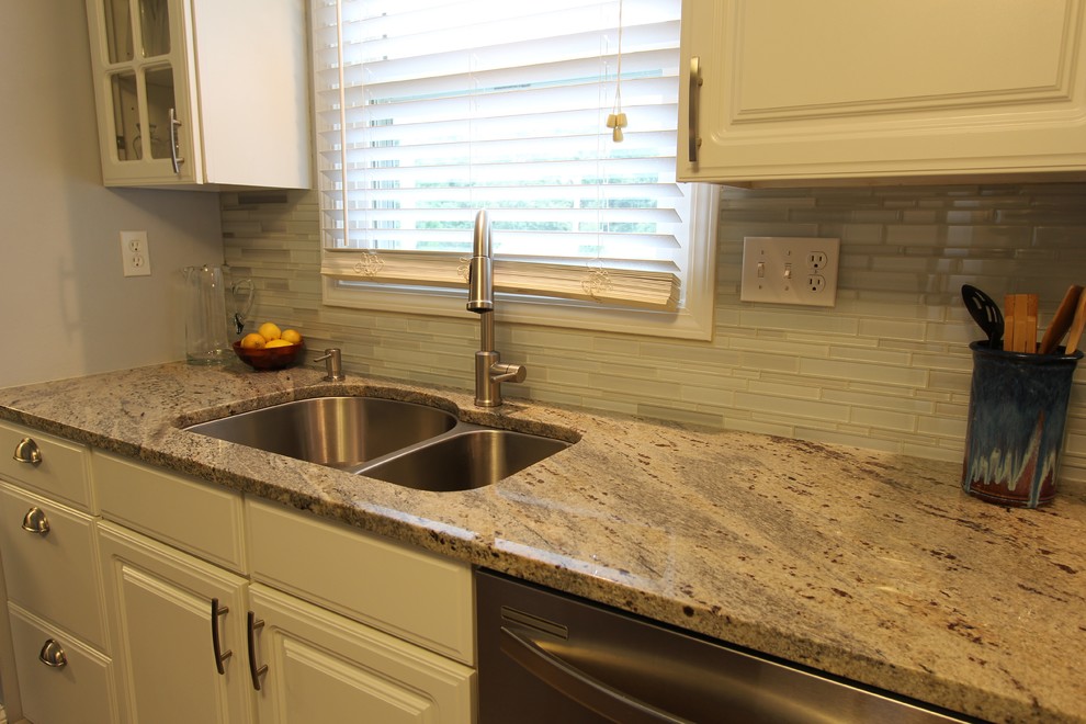 Eat-in kitchen - mid-sized medium tone wood floor eat-in kitchen idea with a double-bowl sink, white cabinets, granite countertops, white backsplash, glass tile backsplash, stainless steel appliances and no island