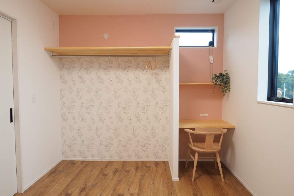 Ispirazione per una cameretta per bambini da 1 a 3 anni moderna con pareti rosa, pavimento in compensato, pavimento marrone, soffitto in carta da parati e carta da parati