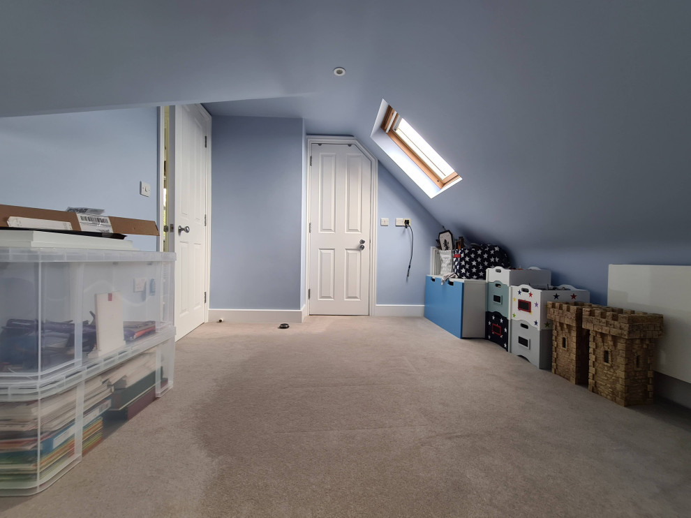 This is an example of a mid-sized traditional open concept family room in London with a game room, blue walls, carpet, a built-in media wall, beige floor and recessed.