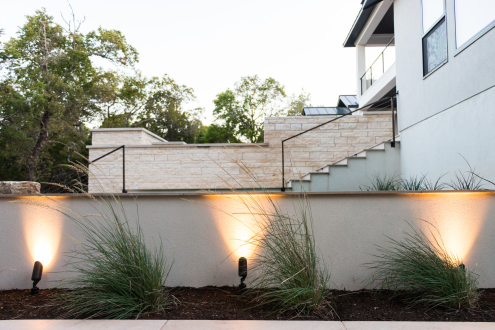 Foto di un grande giardino minimalista esposto in pieno sole dietro casa in estate con pacciame
