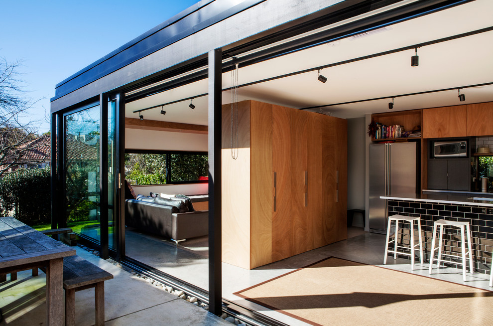 Photo of a contemporary l-shaped open plan kitchen in Auckland with concrete floors and with island.