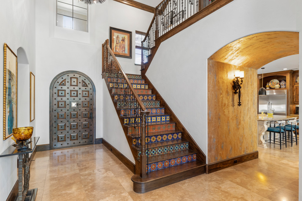 This is an example of a large foyer in Houston with white walls, travertine flooring, a single front door, a brown front door and beige floors.