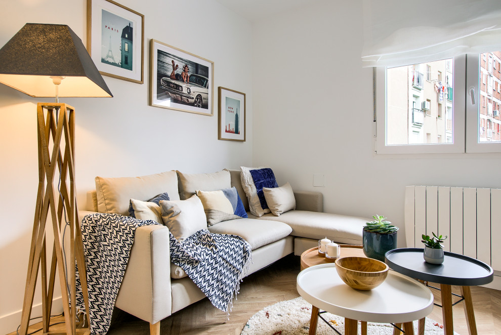 Immagine di un soggiorno scandinavo di medie dimensioni e chiuso con pareti bianche, parquet chiaro e pavimento marrone