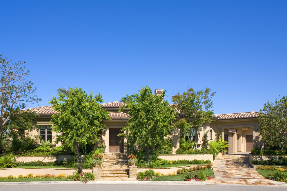 This is an example of a large transitional one-storey stucco beige exterior in Orange County.