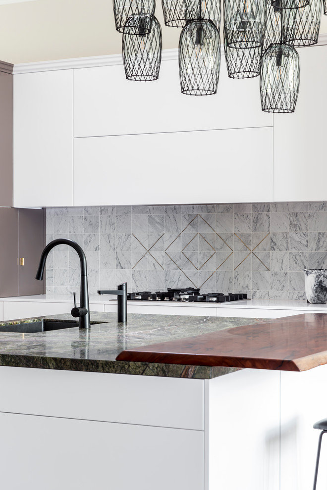 Inspiration for a mid-sized contemporary l-shaped eat-in kitchen in Sydney with an undermount sink, shaker cabinets, white cabinets, marble benchtops, grey splashback, marble splashback, black appliances, dark hardwood floors, with island and brown floor.