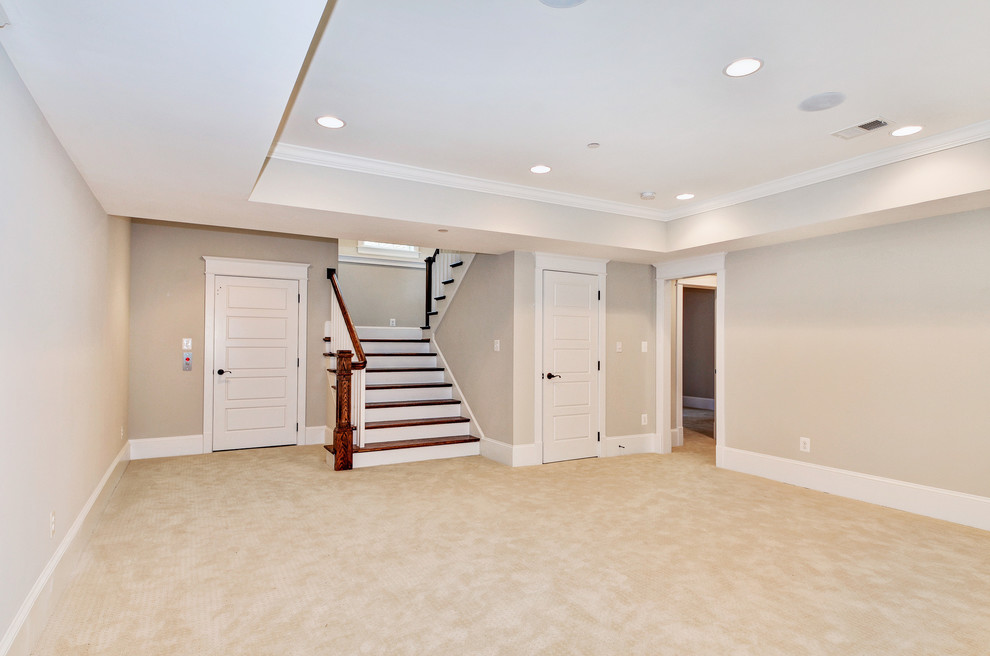 This is an example of a mid-sized arts and crafts walk-out basement in DC Metro with beige walls, carpet, no fireplace and beige floor.