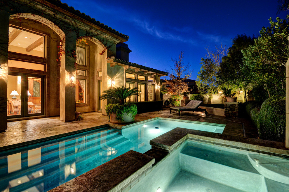 Inspiration for a mediterranean backyard l-shaped pool in Las Vegas with a water feature.