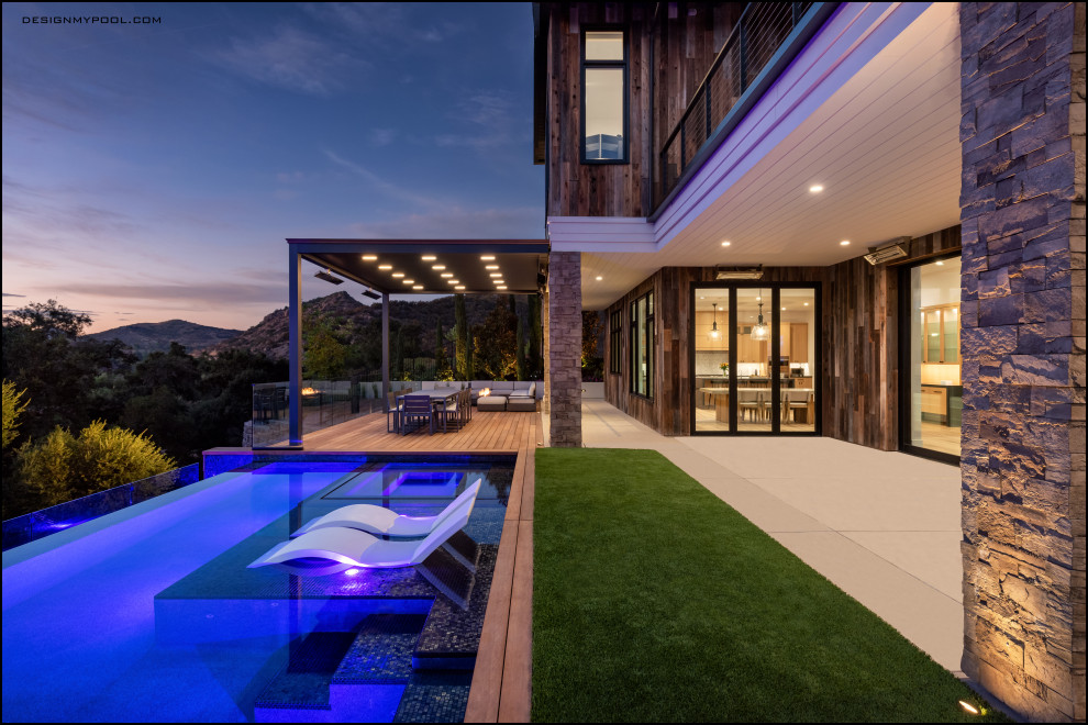 Imagen de piscina infinita minimalista de tamaño medio rectangular en patio trasero con paisajismo de piscina y entablado