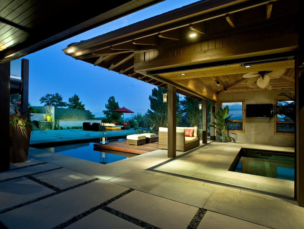 Photo of a large modern indoor rectangular pool in Denver with a pool house and natural stone pavers.
