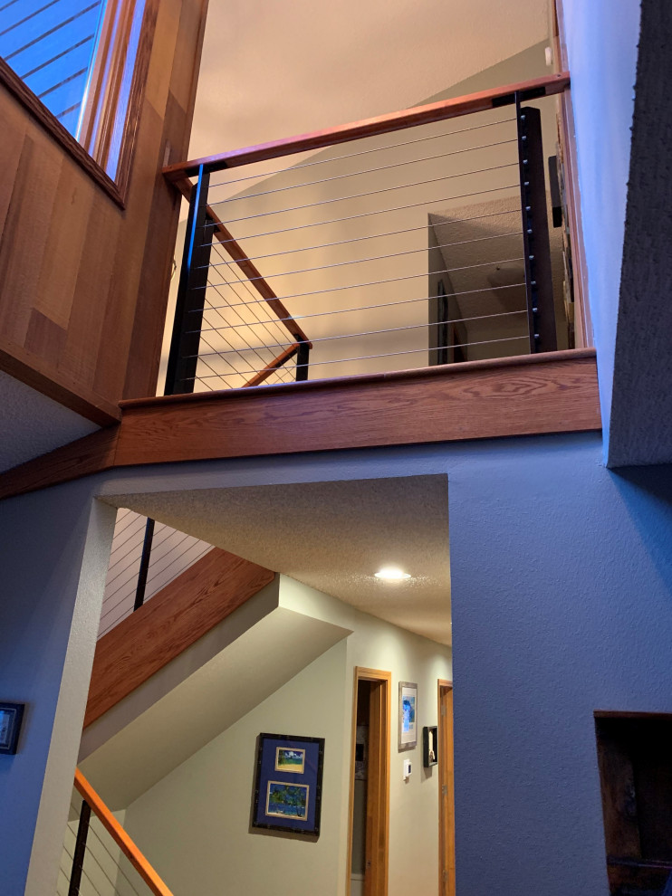 Идея дизайна: угловая деревянная лестница среднего размера в стиле неоклассика (современная классика) с деревянными ступенями, перилами из тросов и деревянными стенами