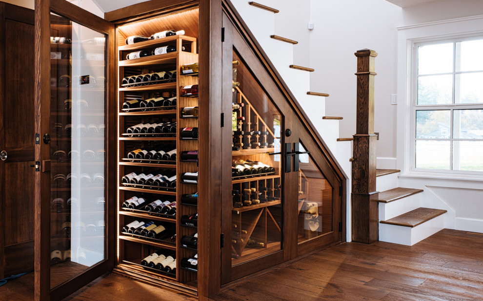 Photo of a small traditional wine cellar in Portland with dark hardwood floors, storage racks and brown floor.