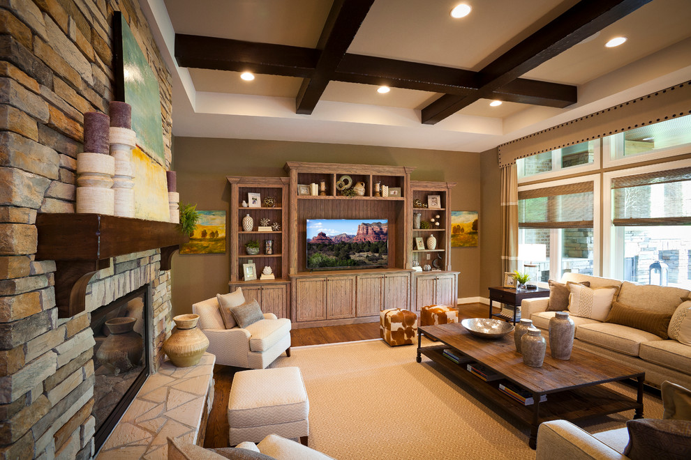 This is an example of a traditional family room in Cincinnati with medium hardwood floors, a standard fireplace, a stone fireplace surround and a built-in media wall.