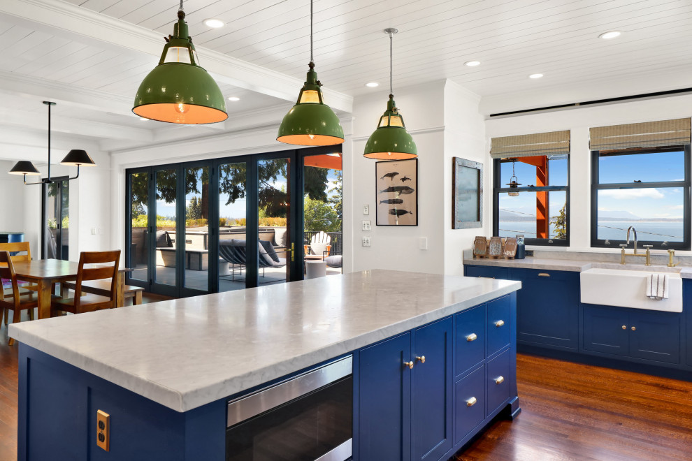 Large traditional l-shaped kitchen/diner in Seattle with a single-bowl sink, flat-panel cabinets, blue cabinets, marble worktops, grey splashback, marble splashback, stainless steel appliances, light hardwood flooring, an island, orange floors, white worktops and a wood ceiling.