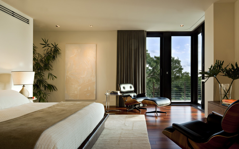 Photo of a modern bedroom in Miami with beige walls, medium hardwood floors and no fireplace.