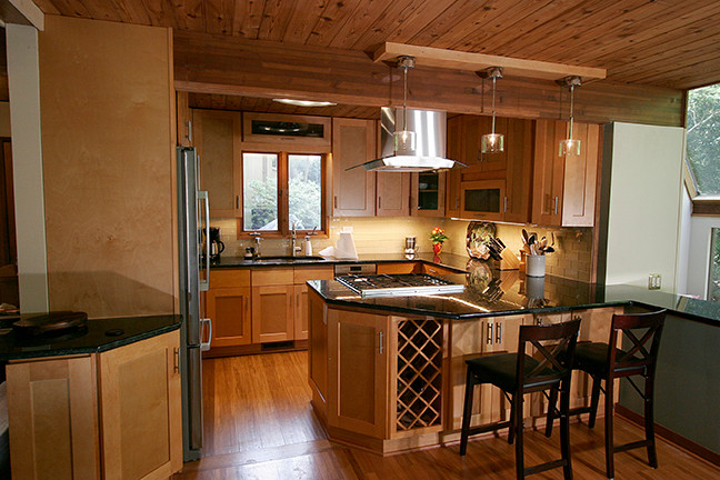Small transitional l-shaped porcelain tile eat-in kitchen photo with shaker cabinets, light wood cabinets, granite countertops, beige backsplash, glass tile backsplash, stainless steel appliances and a peninsula