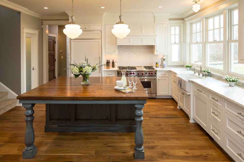 This is an example of a country kitchen in Minneapolis with marble benchtops.