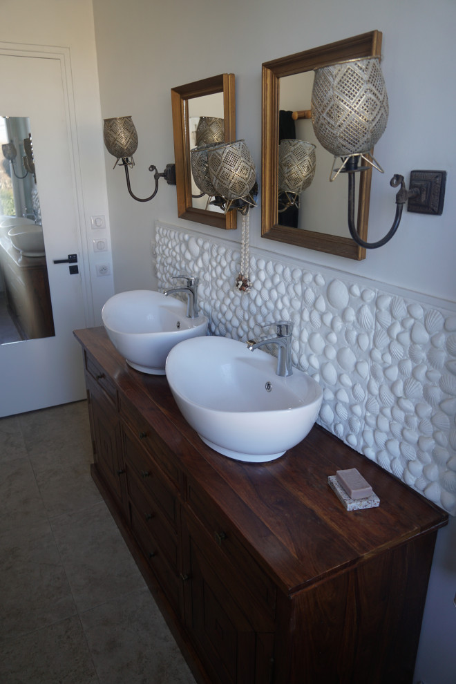 Inspiration for a mid-sized coastal master white tile travertine floor, beige floor and double-sink bathroom remodel in Toulouse with dark wood cabinets, a vessel sink, wood countertops and a freestanding vanity