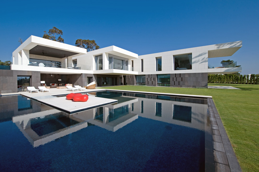 Design ideas for a large modern side yard custom-shaped lap pool in Other with a pool house.