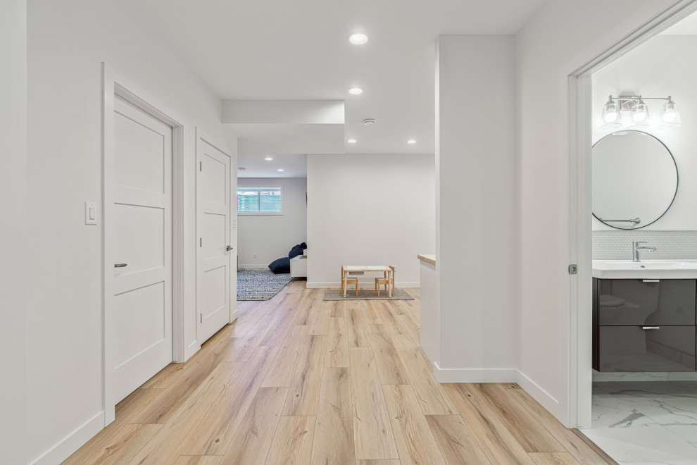 Moderne Kellerbar mit weißer Wandfarbe, Vinylboden und braunem Boden in Edmonton