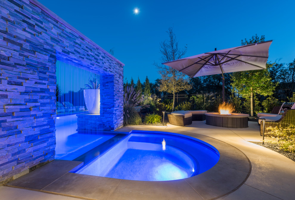 Large transitional backyard custom-shaped lap pool in Dallas with concrete slab and a water feature.