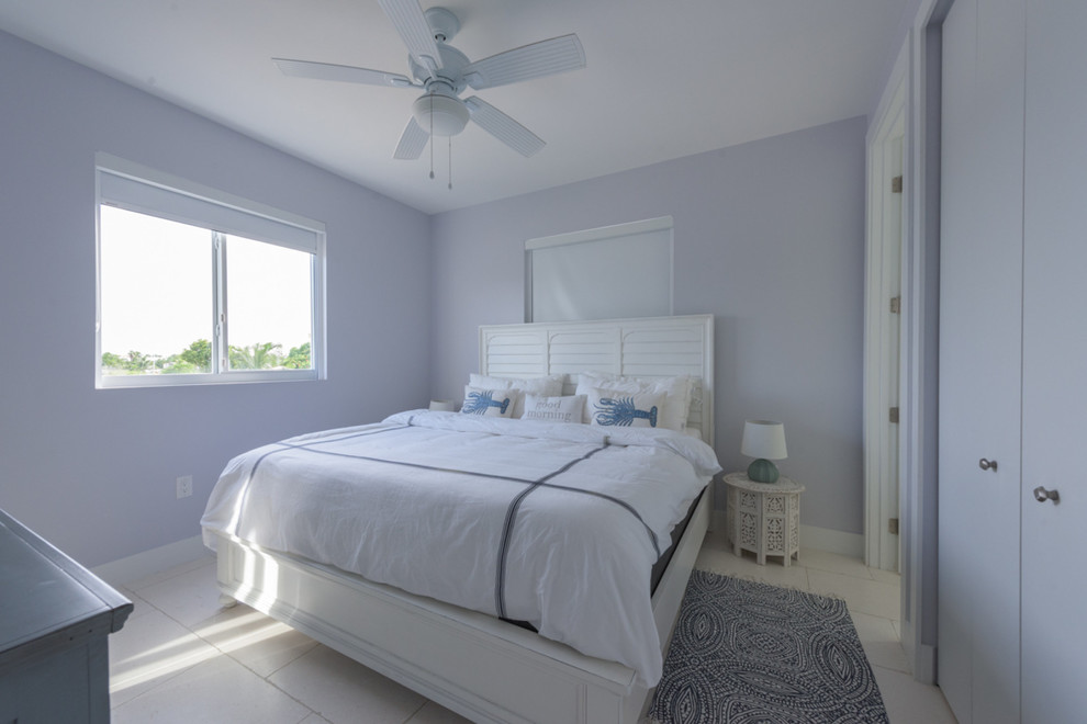 Small beach style guest bedroom in Miami with blue walls, ceramic floors and no fireplace.