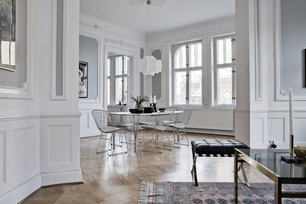 Large scandinavian separate dining room in Malmo with grey walls and light hardwood floors.