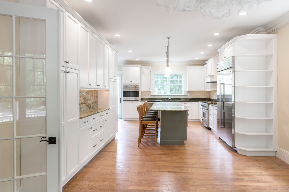 Design ideas for a mid-sized transitional l-shaped kitchen in Boston with an undermount sink, flat-panel cabinets, white cabinets, limestone benchtops, green splashback, metal splashback, stainless steel appliances, light hardwood floors and with island.