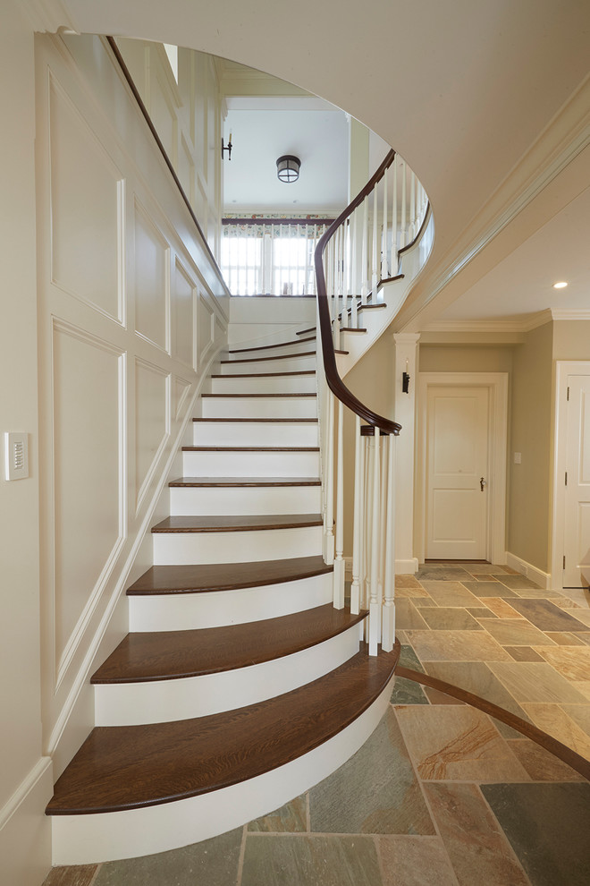 Photo of a mid-sized traditional wood curved staircase in Boston with painted wood risers.