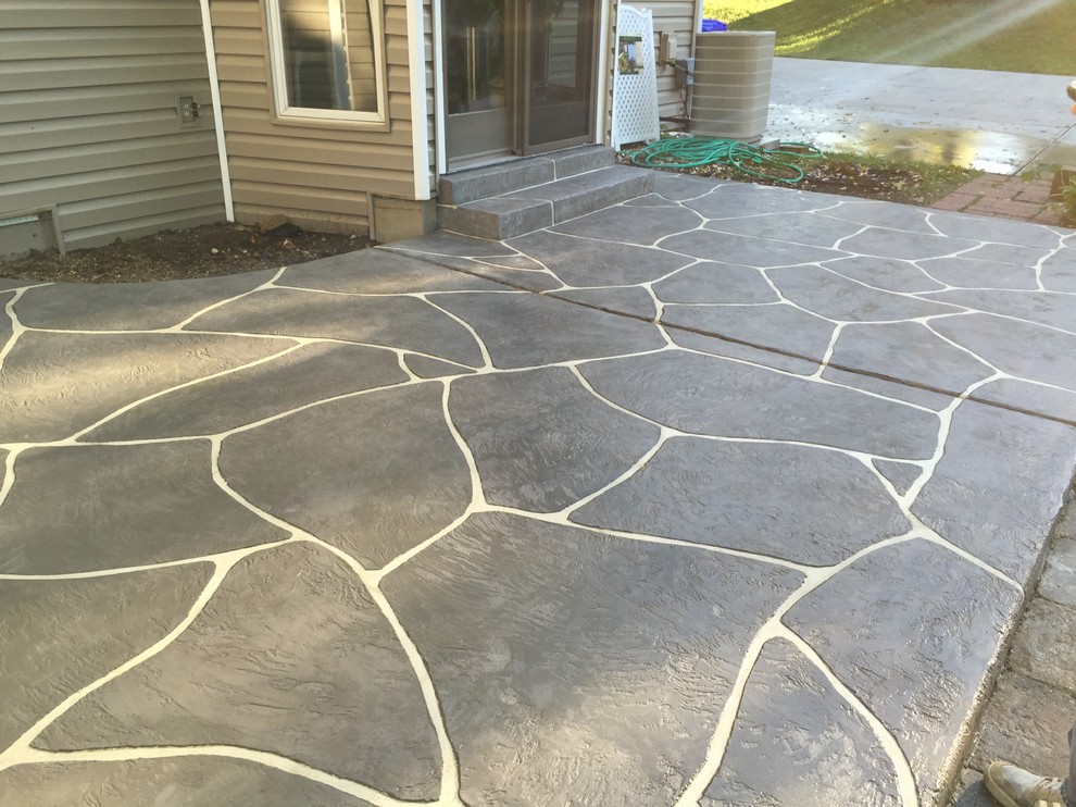 This is an example of a small mediterranean backyard patio in St Louis with stamped concrete and no cover.