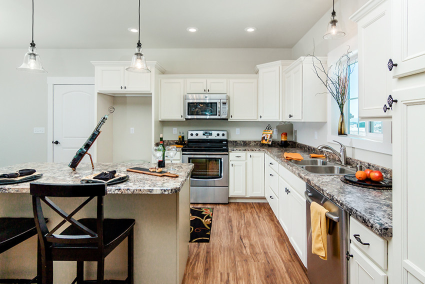 Mid-sized transitional l-shaped medium tone wood floor open concept kitchen photo with an undermount sink, recessed-panel cabinets, white cabinets, granite countertops, stainless steel appliances and an island