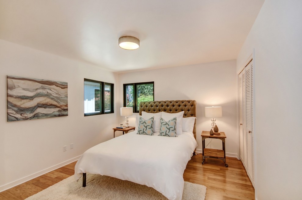 Country guest bedroom in San Francisco with white walls and bamboo floors.