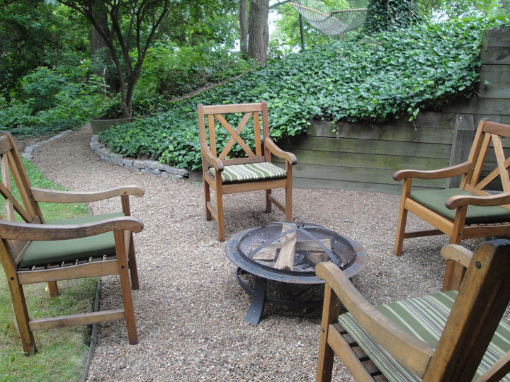 Photo of a mid-sized traditional side yard patio in Other with a fire feature, gravel and no cover.