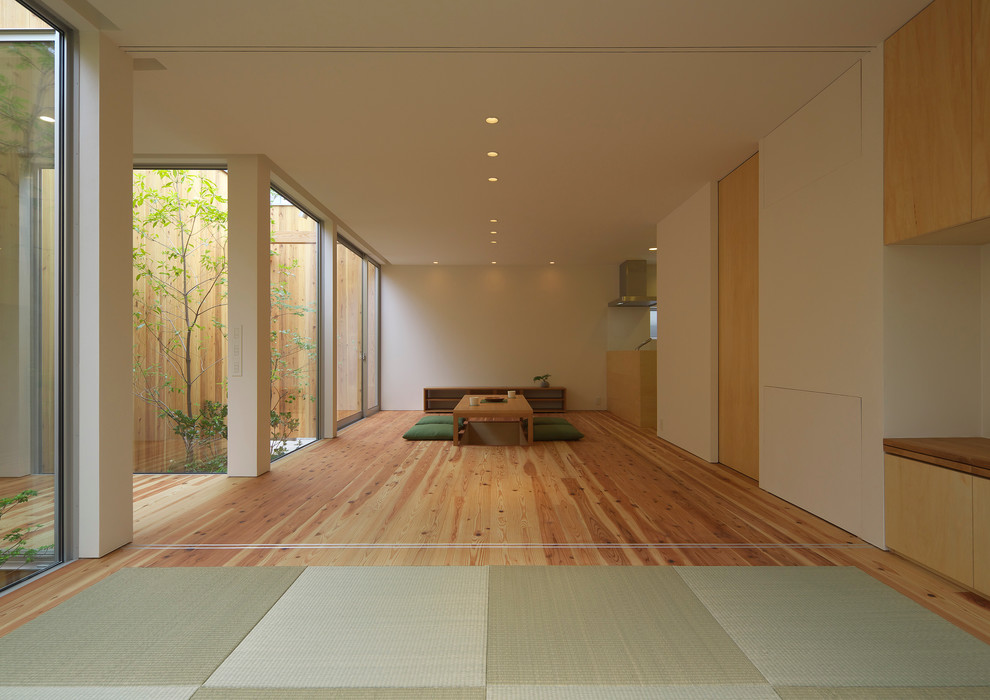 Mid-sized asian living room in Osaka with white walls, tatami floors, no fireplace, a wall-mounted tv and green floor.