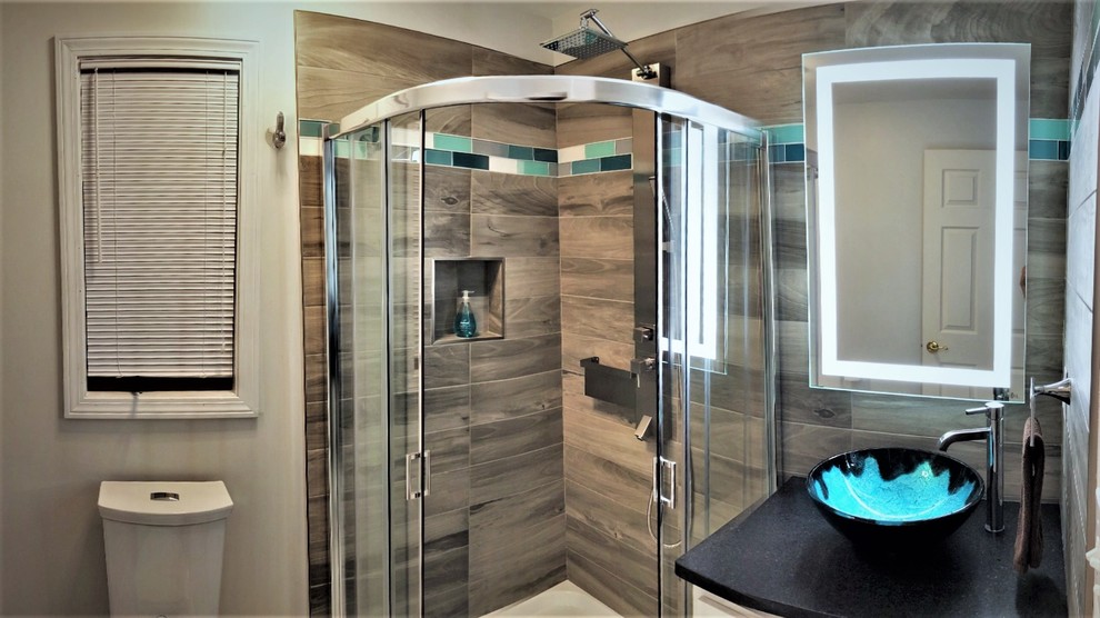 This is an example of a small contemporary 3/4 bathroom in Bridgeport with shaker cabinets, white cabinets, a corner shower, a two-piece toilet, gray tile, porcelain tile, white walls, porcelain floors, a vessel sink, granite benchtops, white floor and a sliding shower screen.