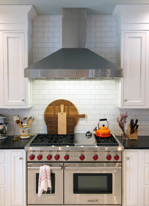 Inspiration for a large transitional l-shaped dark wood floor and brown floor eat-in kitchen remodel in Burlington with a single-bowl sink, shaker cabinets, white cabinets, soapstone countertops, white backsplash, ceramic backsplash, stainless steel appliances, an island and black countertops