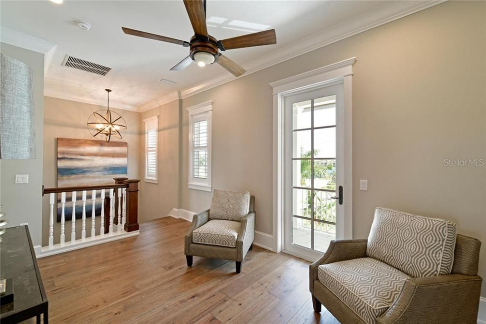 This is an example of a beach style hallway in Tampa with beige walls, medium hardwood floors and brown floor.