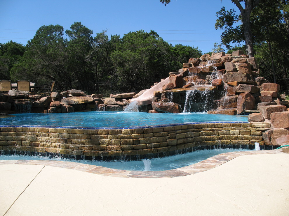 Inspiration for a mid-sized rustic backyard custom-shaped natural pool fountain remodel in Austin with decking