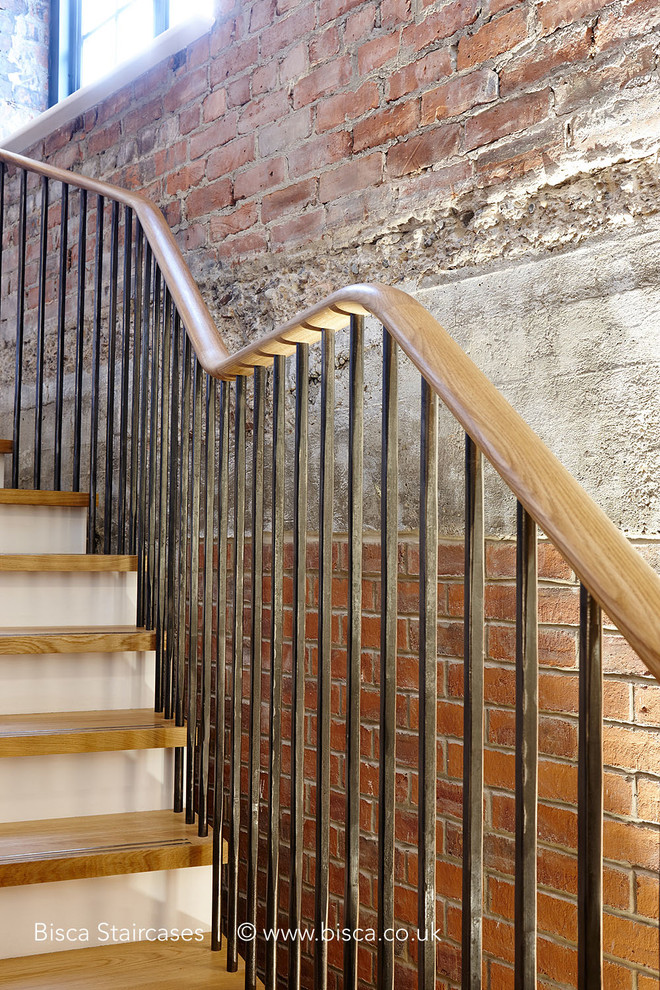 Идея дизайна: большая лестница на больцах в стиле лофт с деревянными ступенями и крашенными деревянными подступенками