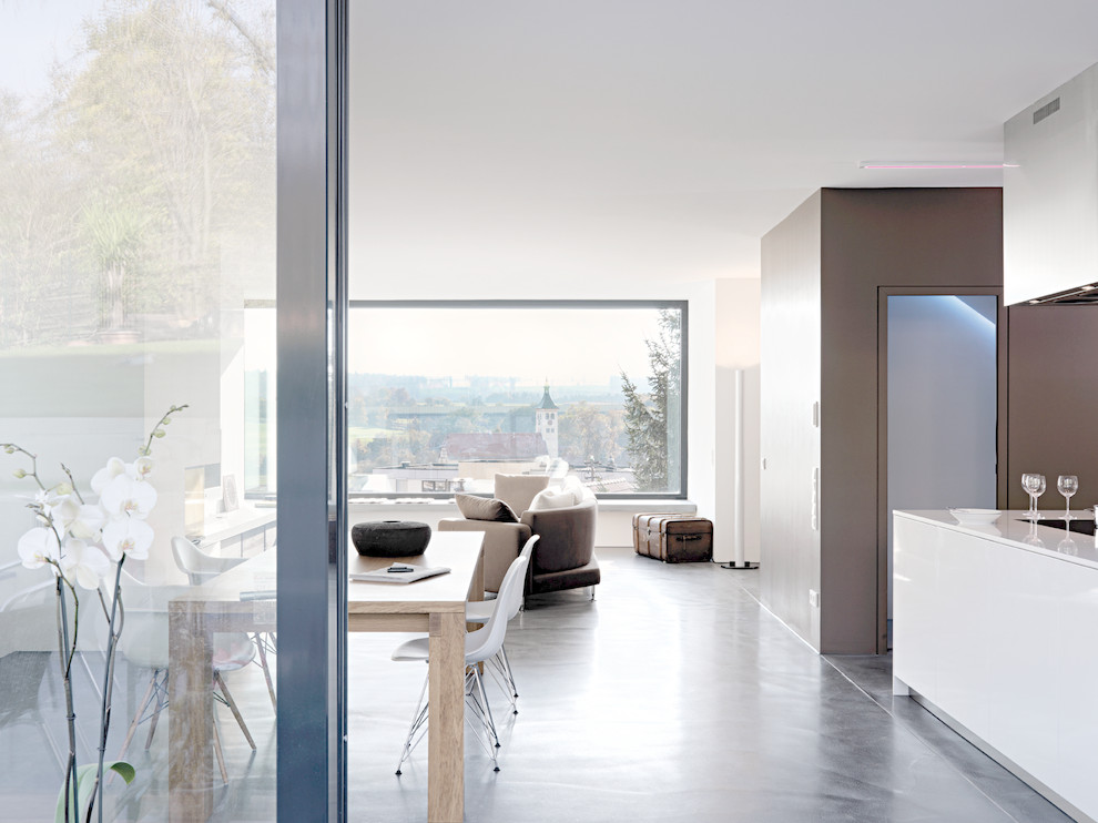 This is an example of a modern dining room in Stuttgart with concrete floors.