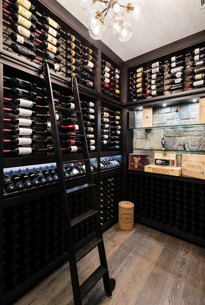 Design ideas for a traditional wine cellar in Vancouver with brown floor, dark hardwood floors and display racks.