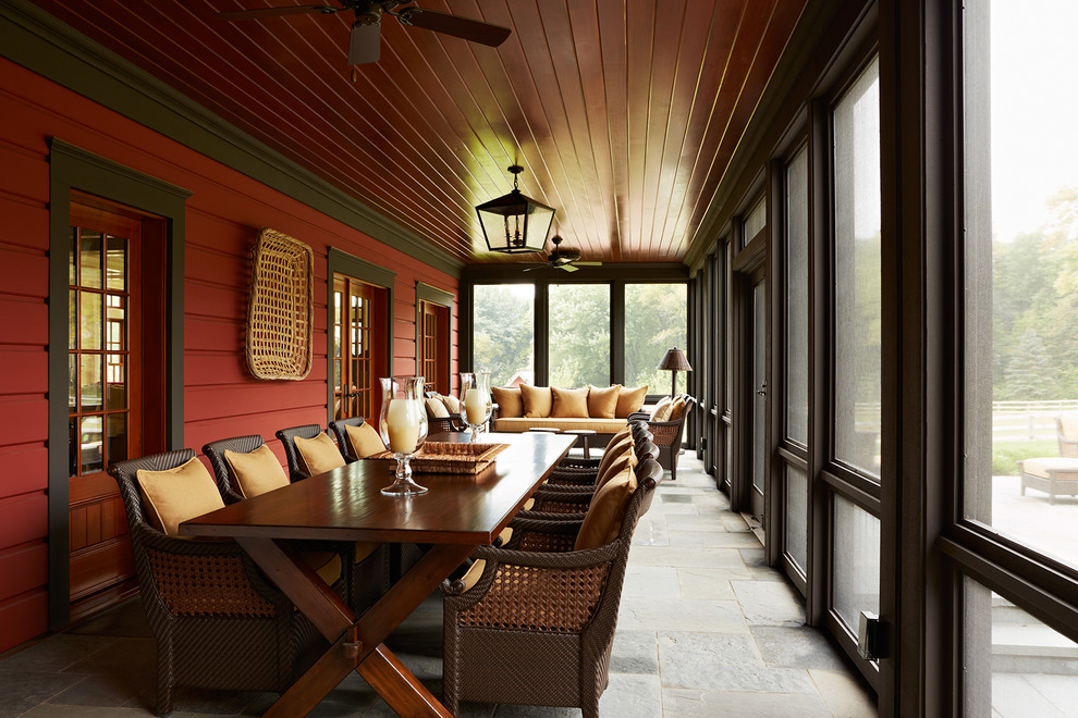 Inspiration for a large country backyard verandah in Minneapolis with natural stone pavers and a roof extension.