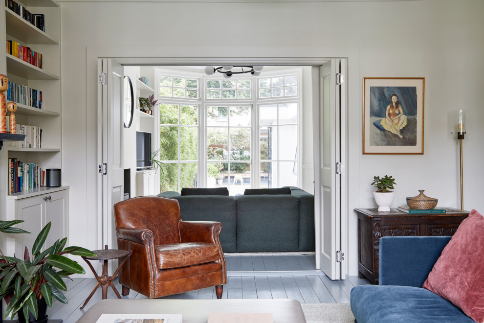 Cette image montre un salon minimaliste de taille moyenne et ouvert avec un mur beige, parquet peint, une cheminée standard, un manteau de cheminée en métal, un téléviseur indépendant et un sol gris.