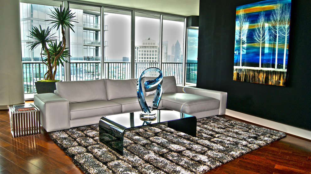 Photo of a mid-sized modern loft-style living room in Atlanta with black walls and medium hardwood floors.