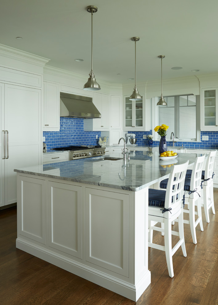 This is an example of a large transitional l-shaped eat-in kitchen in DC Metro with a farmhouse sink, recessed-panel cabinets, white cabinets, blue splashback, subway tile splashback, stainless steel appliances, medium hardwood floors and with island.