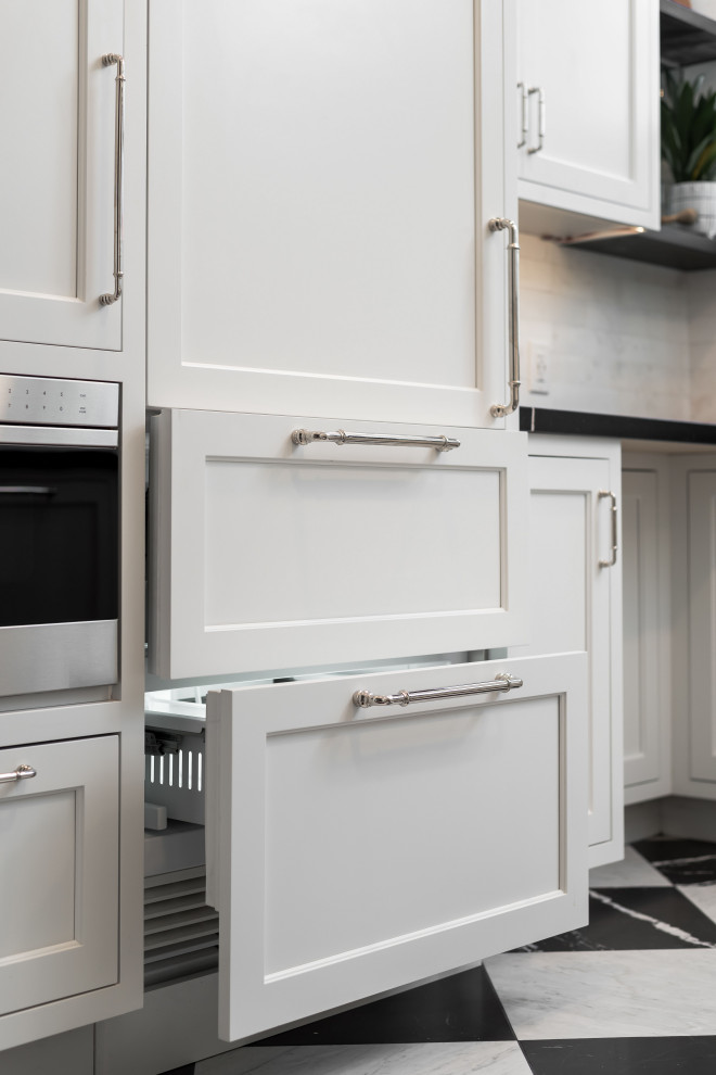 Exempel på ett litet klassiskt svart svart u-kök, med en undermonterad diskho, luckor med profilerade fronter, vita skåp, bänkskiva i kvarts, vitt stänkskydd, stänkskydd i marmor, integrerade vitvaror, marmorgolv och flerfärgat golv